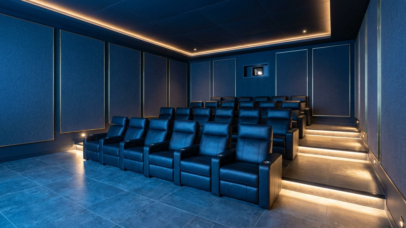Tiered rows of cinema recliners seen from beside the screen